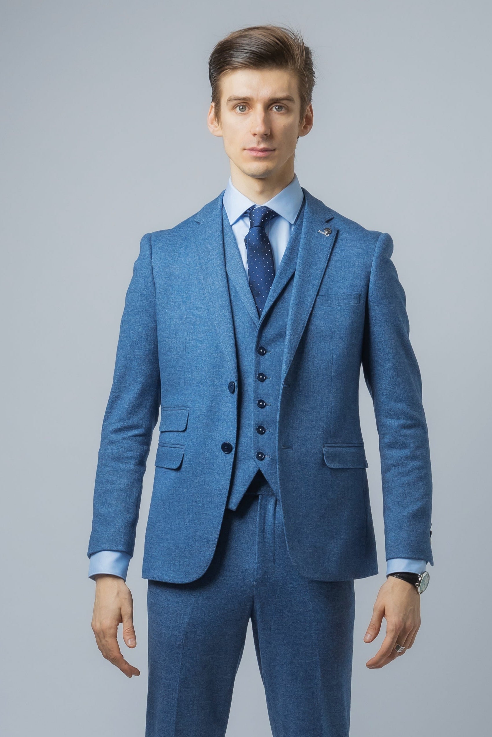 Man wearing a blue suit with a gray background