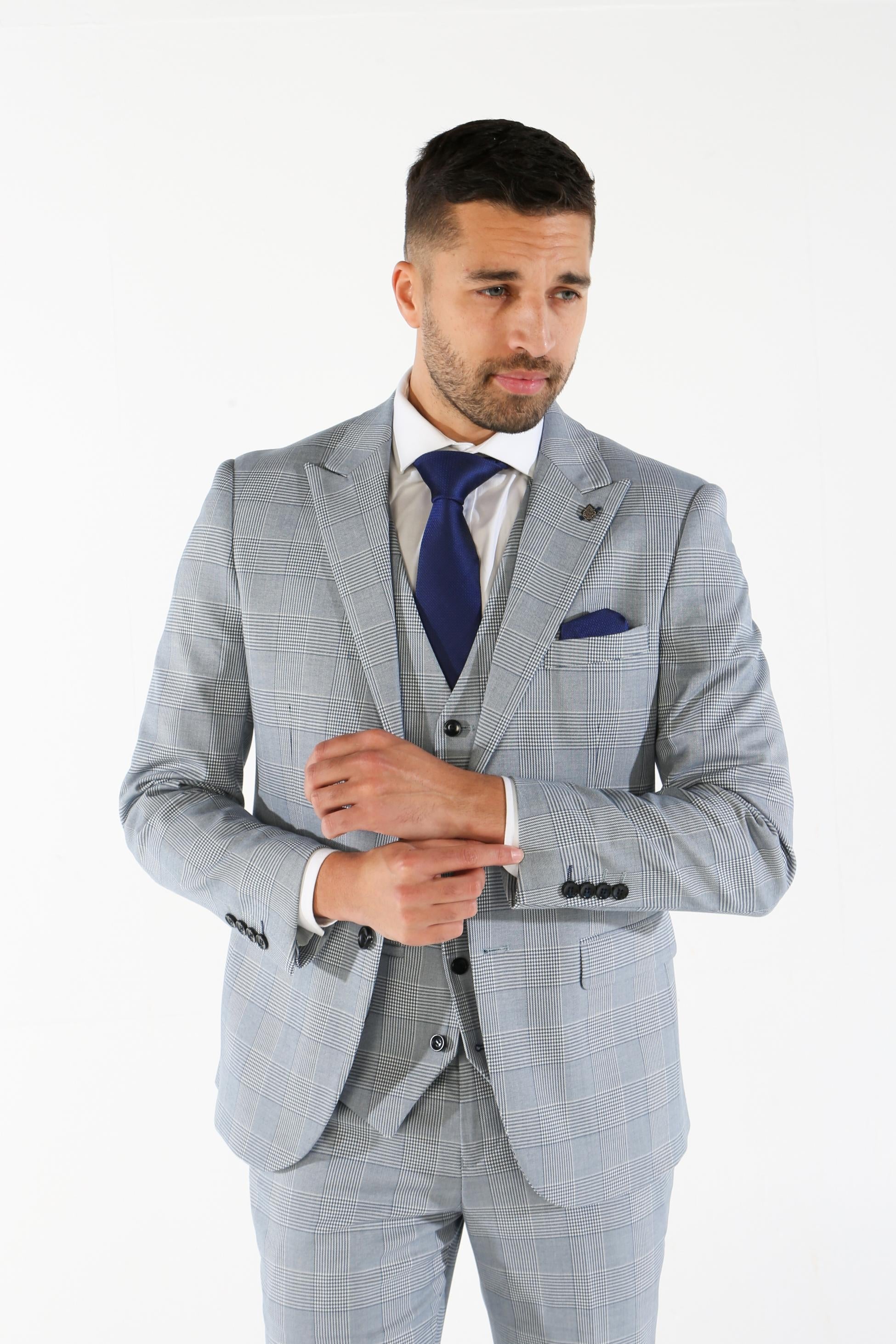 Man wearing a gray checkered suit with a blue tie on a white background