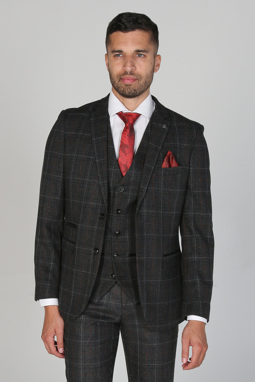 Man wearing a gray checkered suit with a red tie and pocket square on a gray background