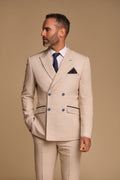 Man wearing a beige suit with a blue tie against a beige background