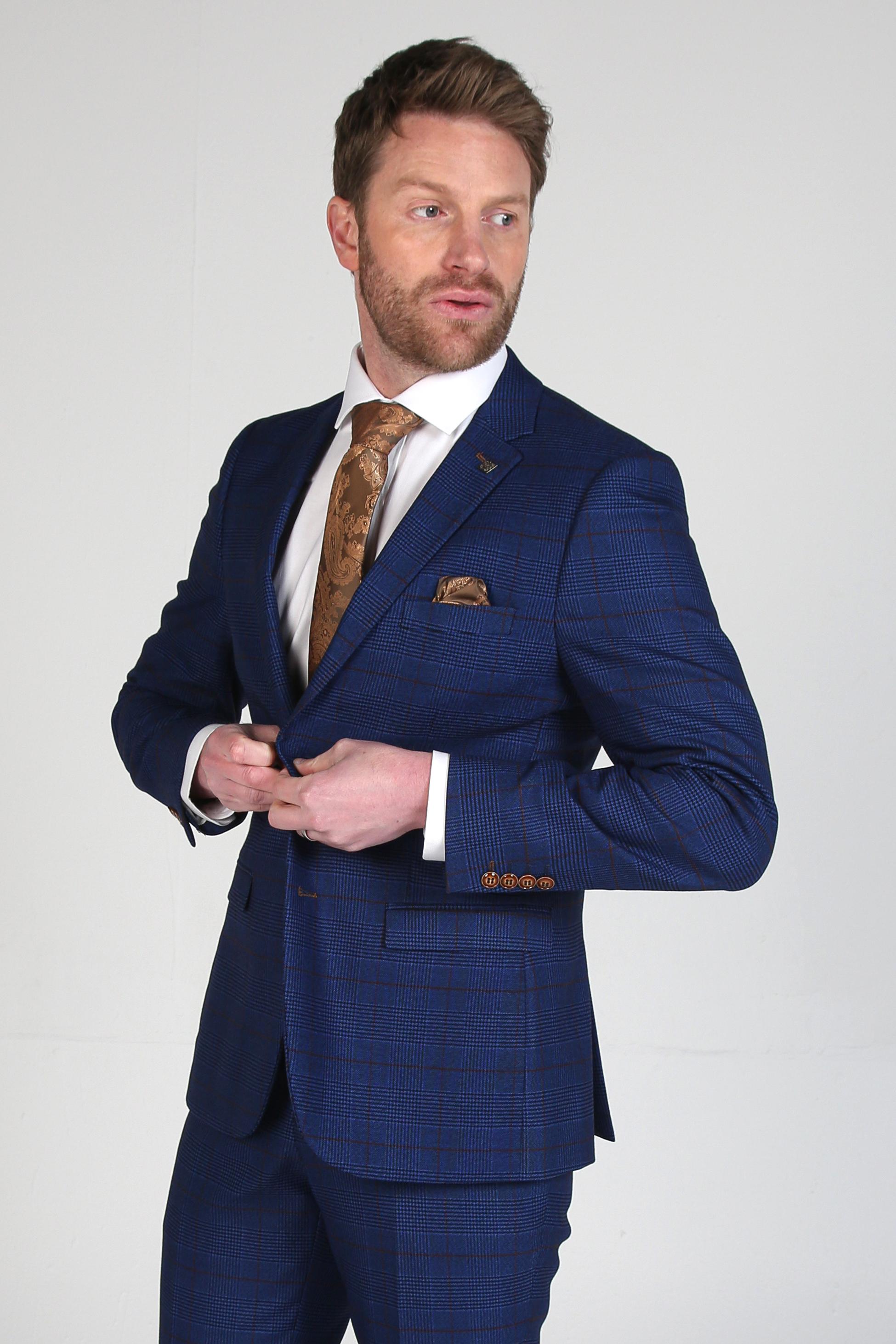 Man wearing a blue suit with a white shirt and brown tie on a light gray background